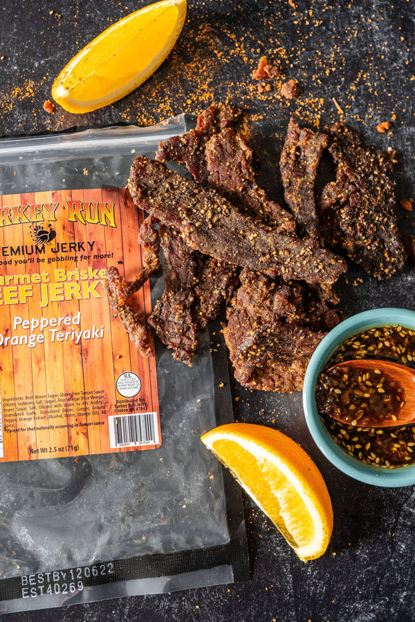Brisket Beef Jerky photo showing Peppered Orange Teriyaki Flavored with seasonings and orange slices